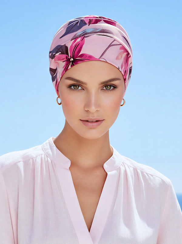 A woman wearing a pink lilac floral chemo cloche cap.